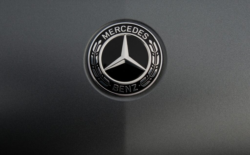 Detailed view of a luxury car logo on a sleek metallic surface.